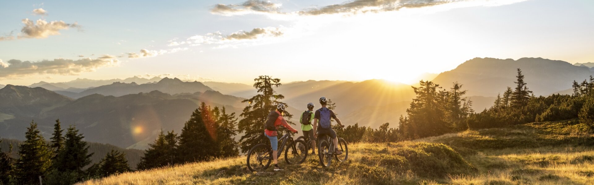 Flachau ist ein wahres Eldorado f¸r (E)-Mountainbiker. Am Bild sieht man eine Gruper von 3 Bikern am Berg die gerade die letzten Sonnenstrahlen des Tages und ein traumhaftes Bergpanorama genieﬂen.
