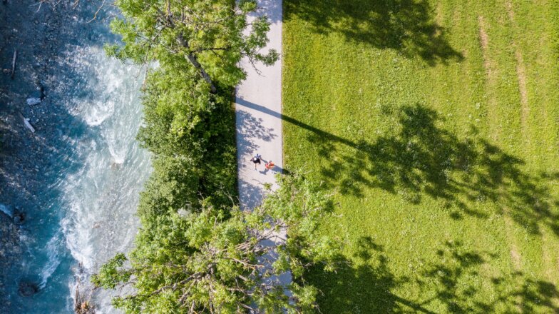 Der Urlaubsort Flachau ist als Teil der Salzburger Sportwelt nicht nur zum Entspannen, sondern auch zum Sporteln ideal. Das wunderschöne Bergpanorama lädt geradezu zum Laufen ein. Bei den verschiedenen Laufstrecken, ist für jeden was dabei. Im Bild sieht man zwei Läufer, die entlang der Enns laufen.