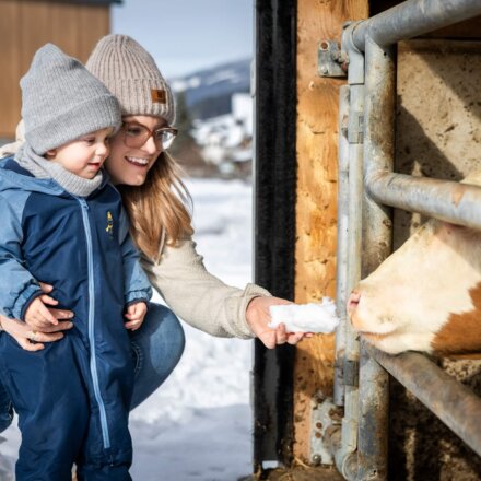 Kind mit Mama streicheln eine Kuh