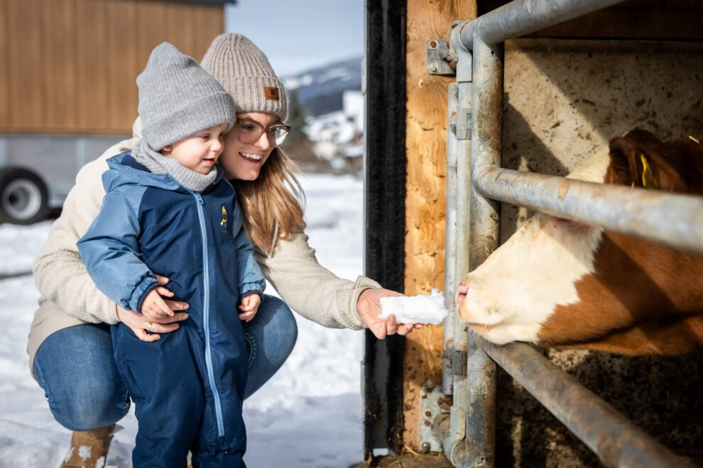 Kind mit Mama streicheln eine Kuh