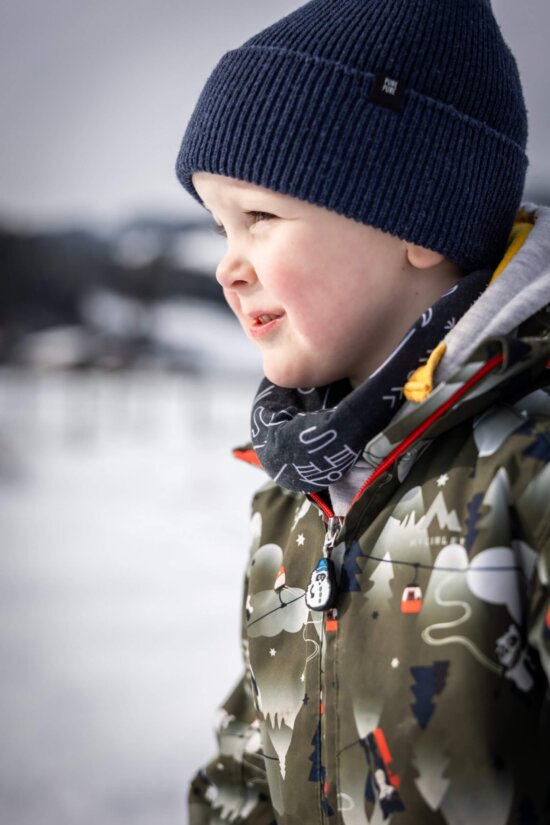 Kleines Kind in Winterkleidung mit Mütze im Schnee