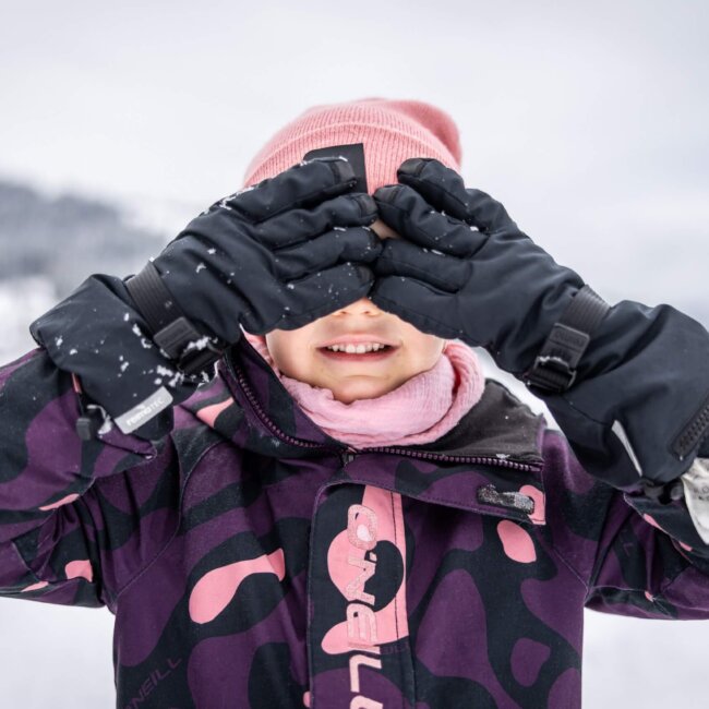 Mädchen hält die Hände vor das Gesicht