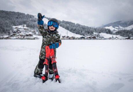 Junge geht Skifahren am Skihügel