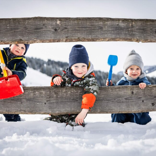 Kinder spielen mit Schaufeln im Schnee