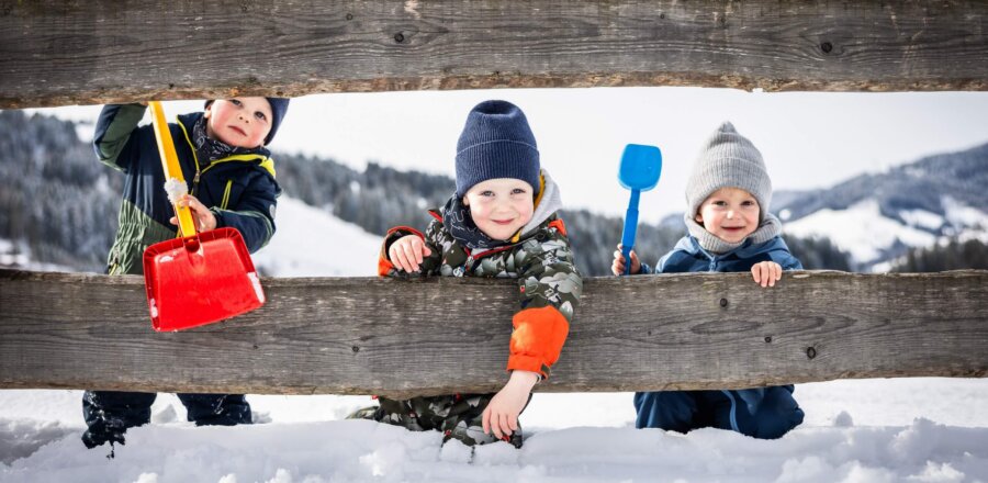 Kinder spielen mit Schaufeln im Schnee
